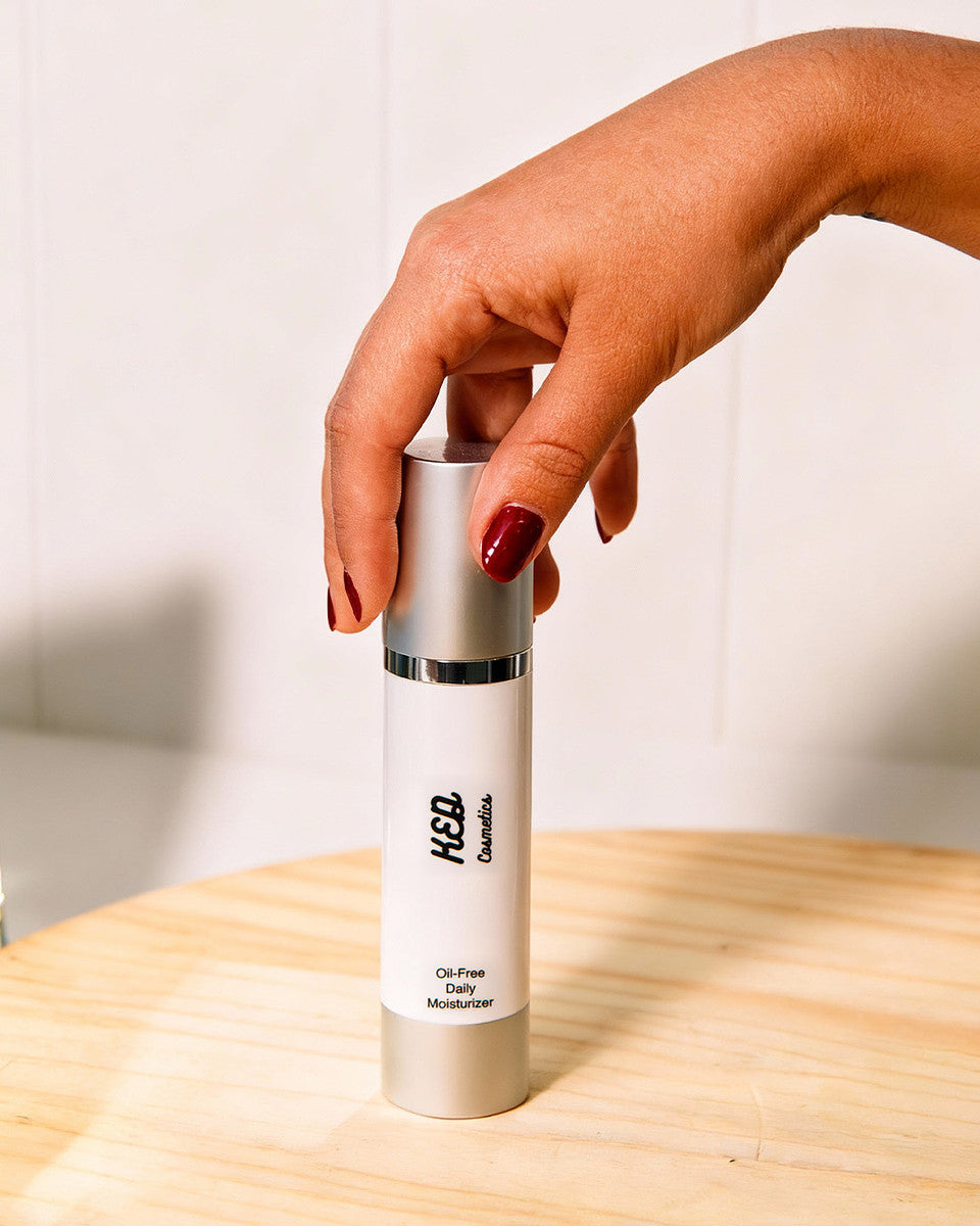 Hand holding a bottle of oil-free moisturizer from new cosmetics products collection.