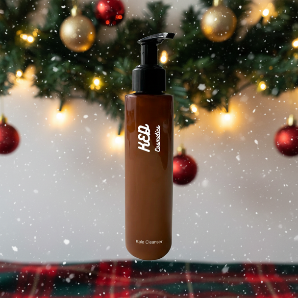 Kale Face Cleanser in a brown pump bottle with a festive background of lights and snow.