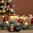 Men's face moisturizer in an elegant jar placed on a festive table with Christmas decorations.