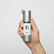 Hand holding Age Defying Serum bottle showcasing age defying serum benefits for hydration and skin rejuvenation.