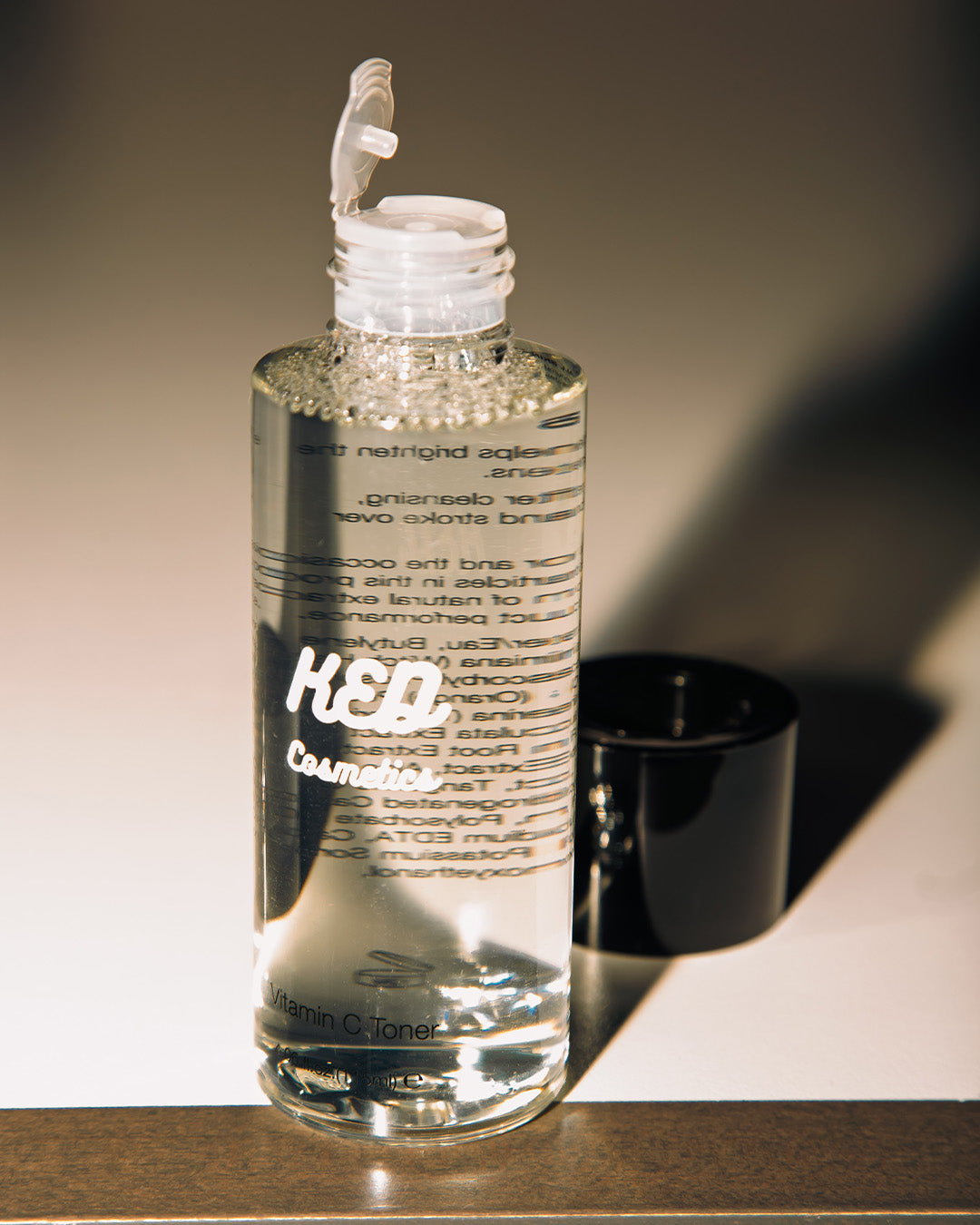 Brightening Vitamin C Toner bottle with clear liquid and black cap, showcasing hydrating skincare benefits.